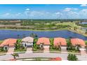 Stunning aerial view of luxurious homes with terracotta roofs near a serene lake and lush golf course at 23781 Waverly Cir, Venice, FL 34293