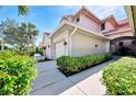 Side view of the home's exterior featuring a well-manicured lawn, shrubbery, and clean sidewalk at 4624 Club Dr # G201, Port Charlotte, FL 33953
