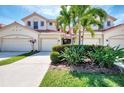 Inviting exterior showcasing the home's well-maintained landscaping, cream-colored stucco, and attached two-car garage at 4624 Club Dr # G201, Port Charlotte, FL 33953