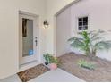 Charming front porch featuring a decorative door, small window, lantern, and manicured plants at 4624 Club Dr # G201, Port Charlotte, FL 33953