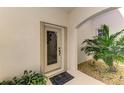 Inviting front entrance with a glass door, a decorative welcome mat, and lush tropical plants, creating a warm ambiance at 4697 Club Dr # 201, Port Charlotte, FL 33953