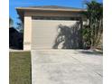A detached two-car garage with a beige exterior, concrete driveway, and manicured lawn at 5262 Weatherton St, North Port, FL 34288
