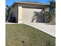 A detached two-car garage with a beige exterior, concrete driveway and manicured lawn at 5262 Weatherton St, North Port, FL 34288