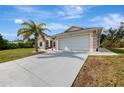 Well-maintained single-story home with a two-car garage and a concrete driveway at 7151 Cork Ln, Englewood, FL 34224