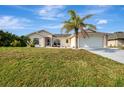 Charming single-story home with a well-manicured lawn and a mature palm tree in the front yard at 7151 Cork Ln, Englewood, FL 34224
