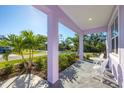 Inviting front porch with elegant pillars and a charming seating area, perfect for enjoying the outdoors at 7499 Ashtabula St, Englewood, FL 34224