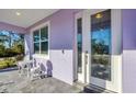 Charming front porch showcasing a cozy seating area with a decorative glass front door and white trim at 7499 Ashtabula St, Englewood, FL 34224