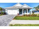 Charming single-story home featuring a well-manicured lawn, stone driveway, and inviting covered front porch at 8375 E Windbound Ct Ct, Sarasota, FL 34240