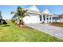 Beautiful home featuring a white garage door, front lawn, and a meticulously landscaped yard at 8375 E Windbound Ct Ct, Sarasota, FL 34240