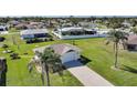 Well-maintained home featuring a lush lawn and mature palm trees, adding to its curb appeal at 9423 El Campo Ave, Englewood, FL 34224