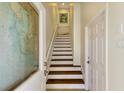 Bright stairwell featuring wood stairs and white risers leading to the upper levels at 10310 Coral Landings Ct # 98, Placida, FL 33946