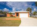Charming single-story home features an attached garage, well-maintained lawn, and a vibrant, colorful exterior paint at 1080 Panda Rd, Venice, FL 34293