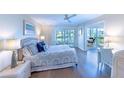 Bright bedroom featuring a ceiling fan, wood floors, and access to a private balcony with lovely water views at 11000 Placida Rd # 702, Placida, FL 33946