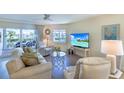 Bright living room featuring comfortable seating, a ceiling fan, and sliding glass doors to the outside deck at 11000 Placida Rd # 702, Placida, FL 33946