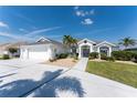 A beautifully landscaped home exterior with a white driveway and lush, green lawn at 12 Sportsman Ter, Rotonda West, FL 33947