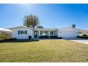 Charming single-story home with a well-manicured lawn and inviting front porch, plus attached garage at 1456 Deer Creek Dr, Englewood, FL 34223