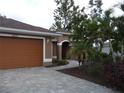 Inviting single-Gathering home showcasing a paver driveway and tropical landscaping at 16137 Alcira Cir, Punta Gorda, FL 33955