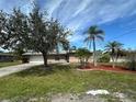 Charming single-story home with a well-maintained lawn, beautiful trees, and a two-car garage at 192 Garden Nw Ave, Port Charlotte, FL 33952