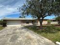 Single-story home with a well-maintained lawn, beautiful trees, and a two-car garage at 192 Garden Nw Ave, Port Charlotte, FL 33952