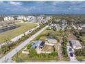 Aerial shot displays a property with a fenced yard, showing proximity to community amenities and local buildings at 2191 Williamsburg Way, Englewood, FL 34224