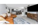 This open-concept living room flows into a kitchen with white cabinets, stainless appliances, and a cozy dining area at 2191 Williamsburg Way, Englewood, FL 34224