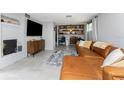Comfortable living room featuring a leather sectional sofa, fireplace, and shelving in a modern aesthetic at 2191 Williamsburg Way, Englewood, FL 34224