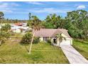 This aerial view showcases the home's layout, surrounding greenery, and long driveway at 35 Michigan Ave, Englewood, FL 34223