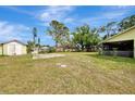 Expansive backyard features mature trees, an outbuilding, and plenty of space for activities at 35 Michigan Ave, Englewood, FL 34223
