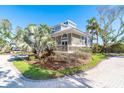 Corner lot home with mature landscaping, brick driveway, and a charming front porch at 36 Seawatch Dr, Boca Grande, FL 33921