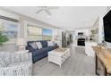 Inviting living room and kitchen featuring a comfortable sofa, open layout, and views through a window at 5041 N Beach Rd # 1A And 1B, Englewood, FL 34223
