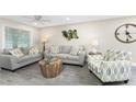 Living room with two gray couches, a patterned chair, and stylish decor at 5041 N Beach Rd # 4A And 4B, Englewood, FL 34223