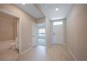 Welcoming foyer featuring light tile flooring, neutral paint and views to a bathroom and bedroom at 5132 Schubert Trl, North Port, FL 34287