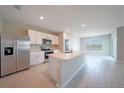 Modern kitchen featuring white cabinetry, stainless steel appliances, and an island with a sink at 5132 Schubert Trl, North Port, FL 34287