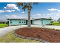 Beautiful turquoise home with a well-maintained front yard and a whimsical pelican statue at 52 Golfview Ter, Rotonda West, FL 33947