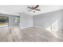 Spacious living room with updated gray walls and updated flooring with ceiling fan at 5881 Talbrook Rd, North Port, FL 34287