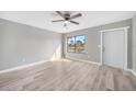 Bright living room with a ceiling fan, and updated floors with view of front yard at 5881 Talbrook Rd, North Port, FL 34287
