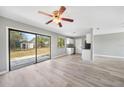 Open living room featuring modern finishes, sliding door access, and a ceiling fan at 5881 Talbrook Rd, North Port, FL 34287