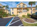 Cream colored condo building featuring a balcony, stairs, metal roof and dedicated parking at 6610 Gasparilla Pines Blvd # 111, Englewood, FL 34224