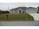 Charming single-story home featuring a well-maintained lawn and a two-car garage at 6998 Dabarsky Ave, North Port, FL 34291