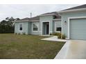 Charming one-story home with an attached two-car garage and a well-manicured lawn at 6998 Dabarsky Ave, North Port, FL 34291