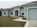 Charming single-story home featuring a well-maintained lawn and a two-car garage at 6998 Dabarsky Ave, North Port, FL 34291