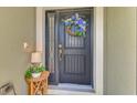 Up close shot of the front door and exterior of the house, with a wreath and lamp at 7027 Mineola Rd, Englewood, FL 34224