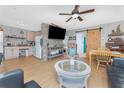 Open-concept living room with a stone-accent wall, wood floors, and cozy furnishings at 7032 Duke St, Englewood, FL 34224