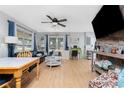 Bright living room with lots of natural light, wood floors, comfortable seating, and a ceiling fan at 7032 Duke St, Englewood, FL 34224