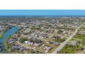 Expansive aerial view of a residential neighborhood with waterfront access and a glimpse of the ocean in the distance at 7305 Innsbrook St, Englewood, FL 34224