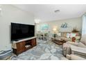 Cozy living room featuring comfortable seating, a large TV, and an adjacent dining area at 8159 Archie St, Englewood, FL 34224
