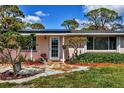 Inviting front door with stone pathway surrounded by colorful flowers and lush greenery at 840 E 7Th St, Englewood, FL 34223