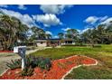 Landscaped front yard with vibrant plants and rock borders enhances this home's curb appeal at 840 E 7Th St, Englewood, FL 34223