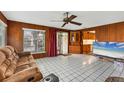 The inviting living room features wood walls, bright tile floors, and sliding glass doors to the back patio at 849 Palmetto St, Englewood, FL 34223