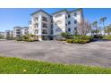 Elegant building exterior featuring balconies, beautiful landscaping, and ample parking spaces at 9203 Griggs Rd # 204, Englewood, FL 34224